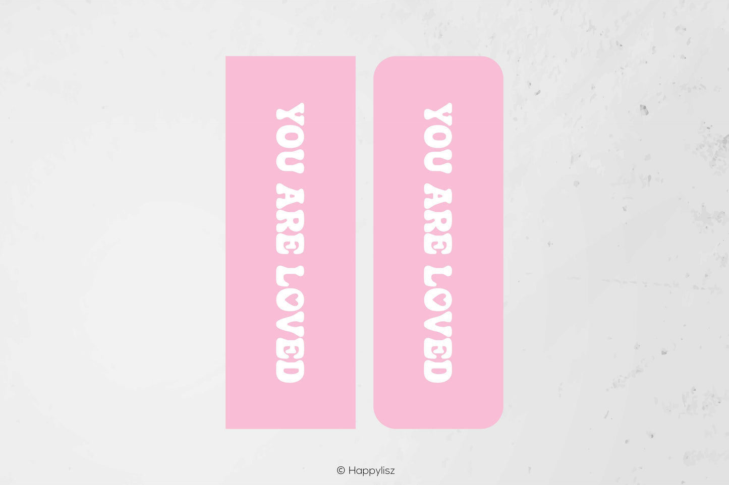 Two pink rectangular labels with rounded corners, each printed with the phrase 'YOU ARE LOVED' in white vertical text, shown on a light textured background.